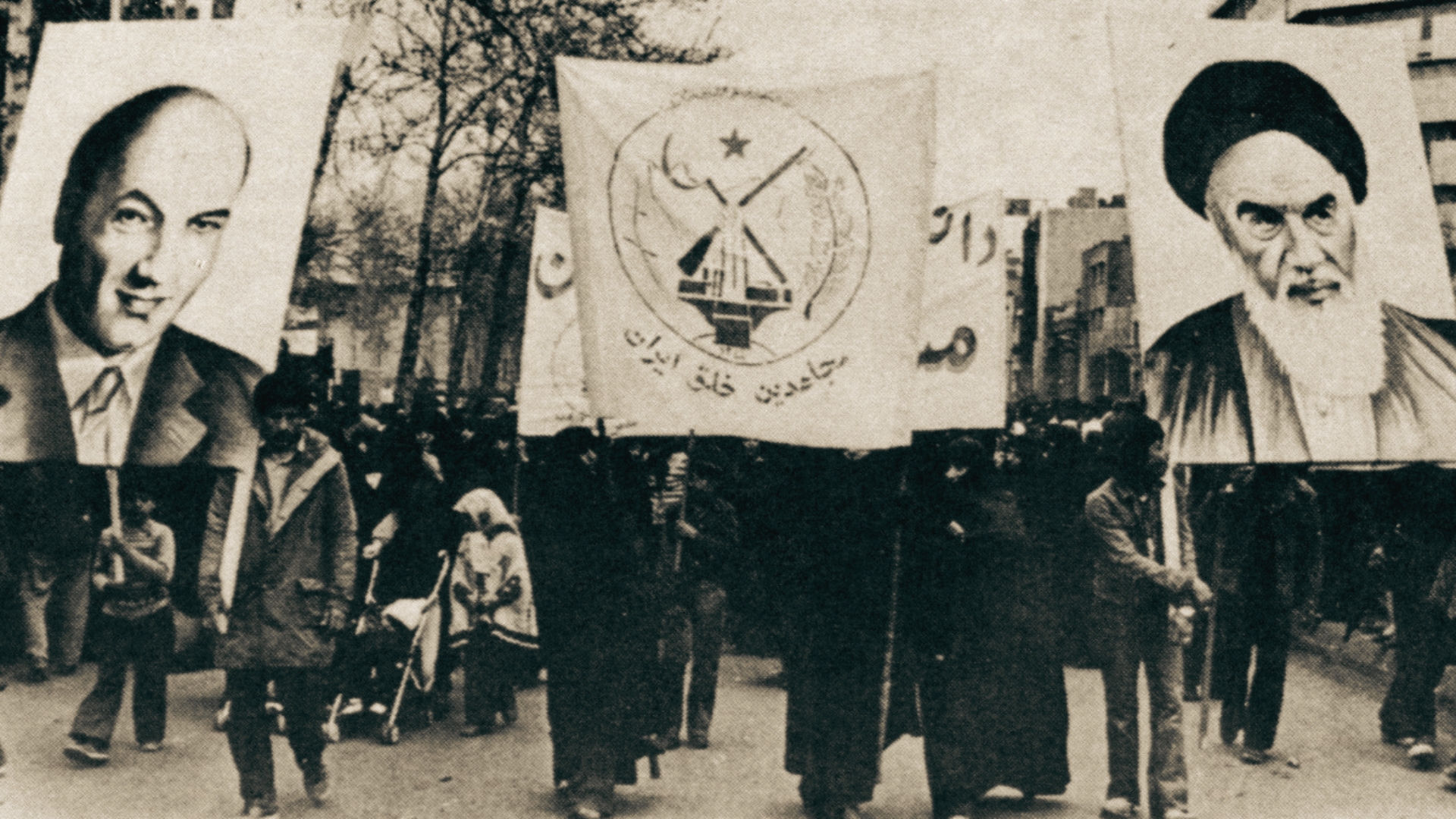 Manifestantes em Teerã carregam cartazes de Khomeini e Ali Shariati, simbolizando a união das frentes religiosas e socialistas contra o Xá.